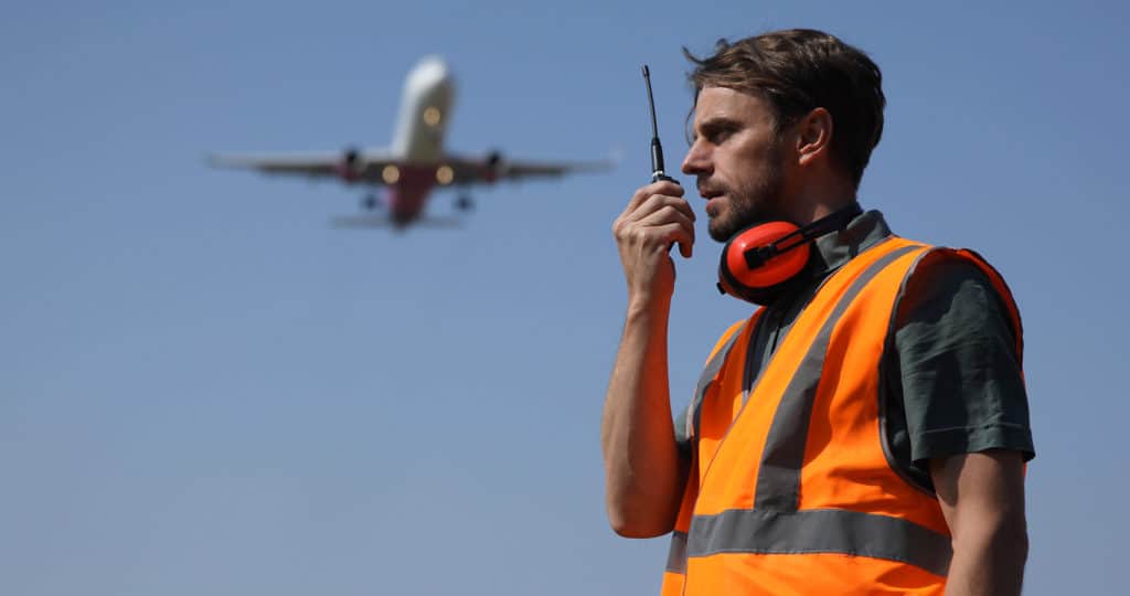 Airport,Ground,Worker,Man,Communicating,Over,Walkie,Talkie,With,Air